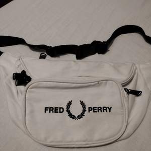 Fred Perry Mens Graphic Waist Bag . Embroidered branding. 100% polyester. Zip fastening main compartment and front pocket. Adjustable strap with clip. Size: 36x16x8cm approx.