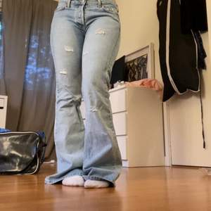 Coola lågmidjade ljusblå bootcut jeans! Supersnygga jeans med hål lite här och där de är lågmidjade och fint utsvängda. De är i mycket bra skick men ganska så mycket för långa på mig som är 164cm. Innerbenslängden är 80cm och midjemåttet är 84cm. Priset kan diskuteras men är pluss frakt :)