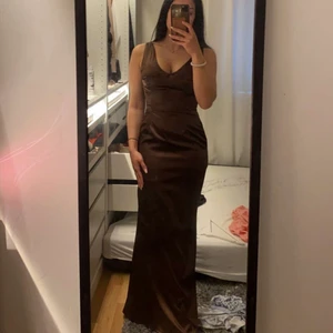 Lång brun satin klänning - Storlek S. Prislapp kvar hämtas upp i Botkyrka eller frakt men då står köparen för det . 