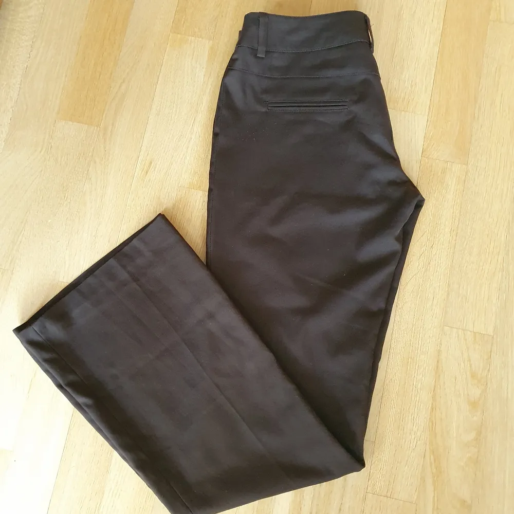 Lågmidjade bruna kostymbyxor som är utsvängda i storlek 36! Köpta någon gång i början på 2000talet men i bra skick! höftmåttet är 80cm och benlängden 81 cm<3. Jeans & Byxor.