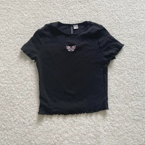 Crop top - Croppad svart topp från H&M, med en liten fjäril detalj i mitten. I storleken S, stretchig material. Säljer för 50kr 🦋