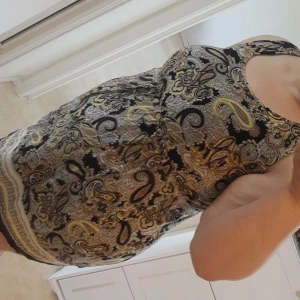 HM klänning - Flerfärgad klänning i storlek L. Den har ett snöre runt midjan som man kan dra åt passformen.