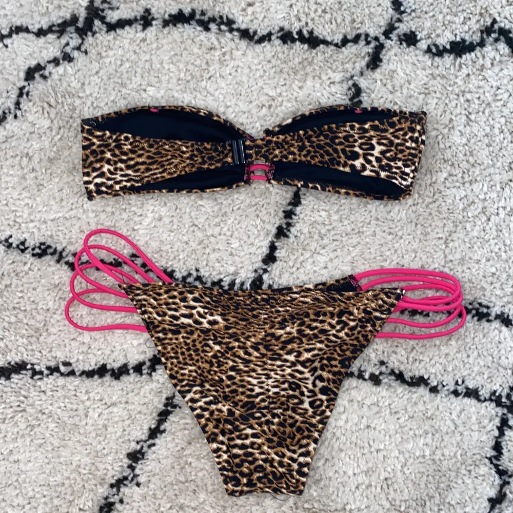 Lejopardmönstrad bikini med rosa detaljer från Nelly beach. Överdelen är i storlek M och nederdelen är i storlek L.. Övrigt.