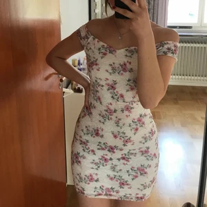 Blommig klänning - Supergullig kort sommarklänning som endast blivit använd vid ett tillfälle. Kan även användas på andra sätt än off-shoulder. 