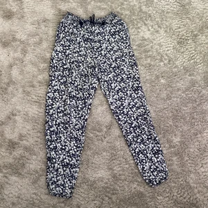 Tunna luftiga byxor strlk 146 - Mörkblåa med vita blommor högmidjade räcker ner till över fotknölarna