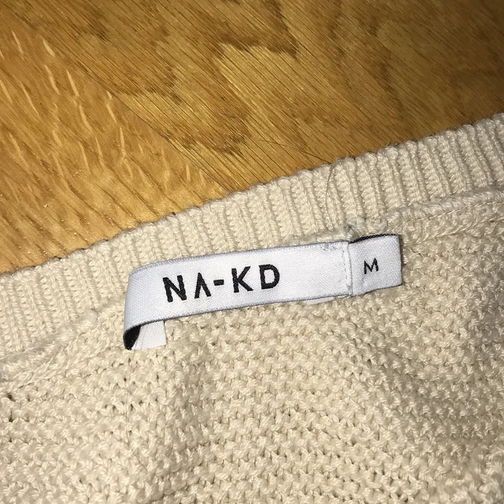Enärmad beige stickad tröja från NAKD. . Stickat.