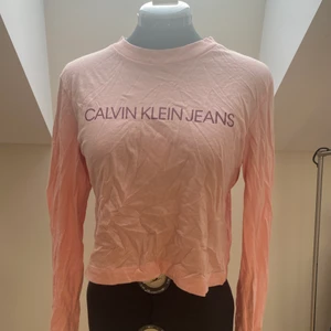 Calvin klein långärmad t-shirt - Säljer denna supersöta topp från Calvin Klein! Använd ett fåtal gånger och i superbra skick! Passar mellan S-M 💕