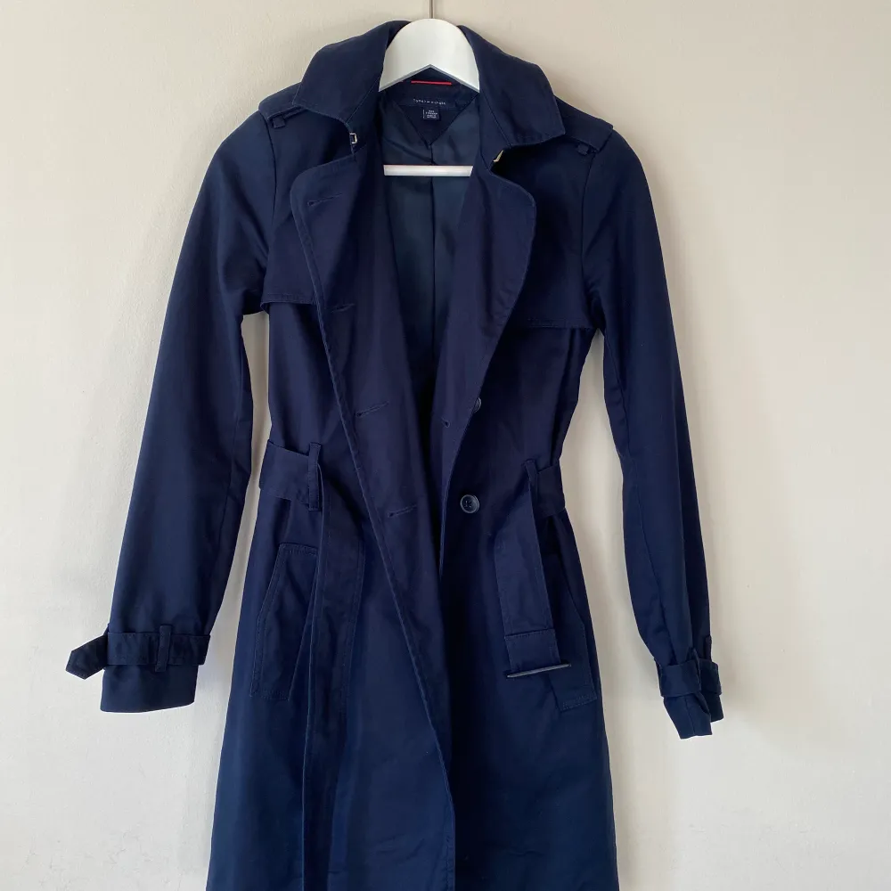 En jättefin, marinblå trenchcoat från Tommy Hilfiger i storlek XXS som köptes i en av deras butiker för några år sedan. Kappan är i nyskick. Skriv gärna för fler bilder :) . Jackor.