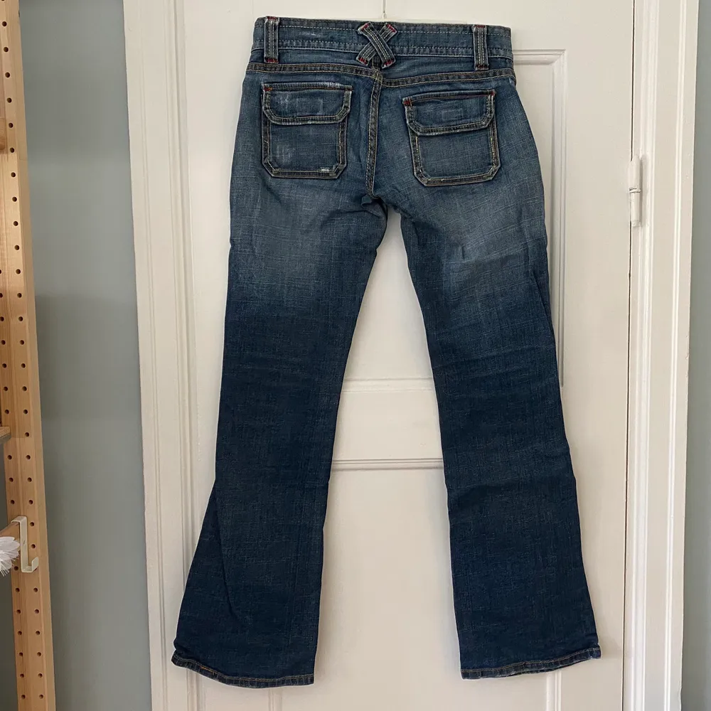 Säljer dessa low waist jeans från blueasphalt. Supersnygga med sömmar i olika färger! Mycket bra skick förutom att framknappen saknas. Midja ca 82 cm och längd innerben är 80 cm.. Jeans & Byxor.