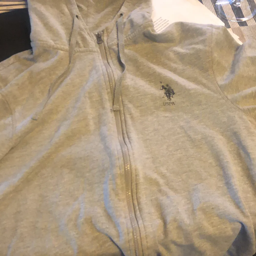 En grå us polo hoodie, skick 9/10 använd få gånger inga hål. Ny pris . Tröjor & Koftor.