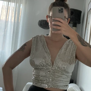 Glittrig festtopp  - Paljett/glitter topp från Gina Tricot i storlek S. Använd ett fåtal tillfällen. Den är lite sliten men annars i bra skick.