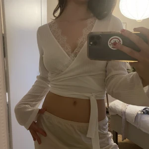 Vit omlott topp - Vit topp som går att knyta runt. Ny skick. Med lite vida ärmar