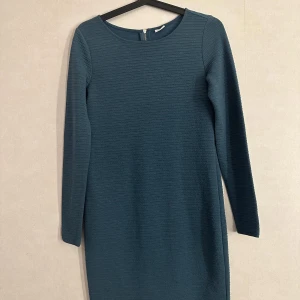 Klänning - Jättesnygg klänning i lite grövre material. Är storlek XS men jag tyckte att den var lite stor så kan nog passa en liten S. Färgen är blå/grön skulle jag säga.