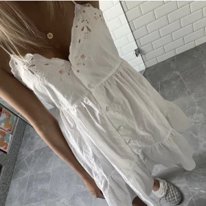 Vit zara klänning - Säljer denna jättefina klänning med broderade blommor från Zara, bara använd 1 gång💕Lånad bild