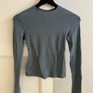 SKIMS tröja säljes - Säljer SKIMS cotton jersey long sleeve t-shirt i färgen Kyanite. Storleken är XS men passar bra på mig som är en normal 38 då den är extremt stretchig i materialet. Säljer på grund av att jag inte fick användning för den då det inte helt var min färg.