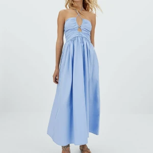 Klänning - Superfin midi klänning fårn Stradivarius som går att knyta på flera olika sett. Klänningen har resår i ryggen vilket gör att den passar olika storlekar på bysten. Den har även band som man kan spänna. 