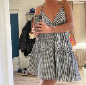 Klänning - Supersöt rutig klänning till sommaren! Den är stretchig där bak och man knyter både i ryggen och i nacken, därför osäker på storlek. Lånade bilder 