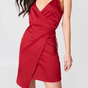 Röd Klänning NAKD 38 S-M - Säljer nu denna Omlottsklänning ifrån NA-KD x Linn Ahlborg. Klänningen är i fint skick, har använts ett fåtsl gånger. ⚘  Alla kläder som har använts tvättas innan de skickas 🌱  Size: 38  Vid frågor eller funderingar kontakta mig gärna ❤🌻🤝😊