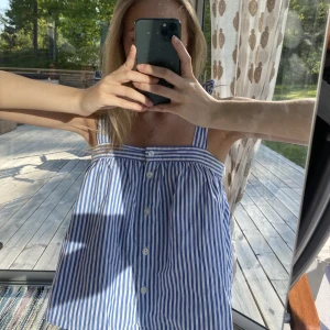 Randig topp - Söt randig topp med rosetter på axlarna!🩵🤍