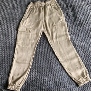 Tunn byxa - Jag säljer dessa glansiga, tunna, oanvända byxor på grund av att jag inte kommer till användning. Köpta på bikbok storlek xs köpta för ungefär 300kr säljer därför för 70kr. 2 fickor med dragkedja 2 utan. tryck inte på köp nu kontakta gärna mig innan.