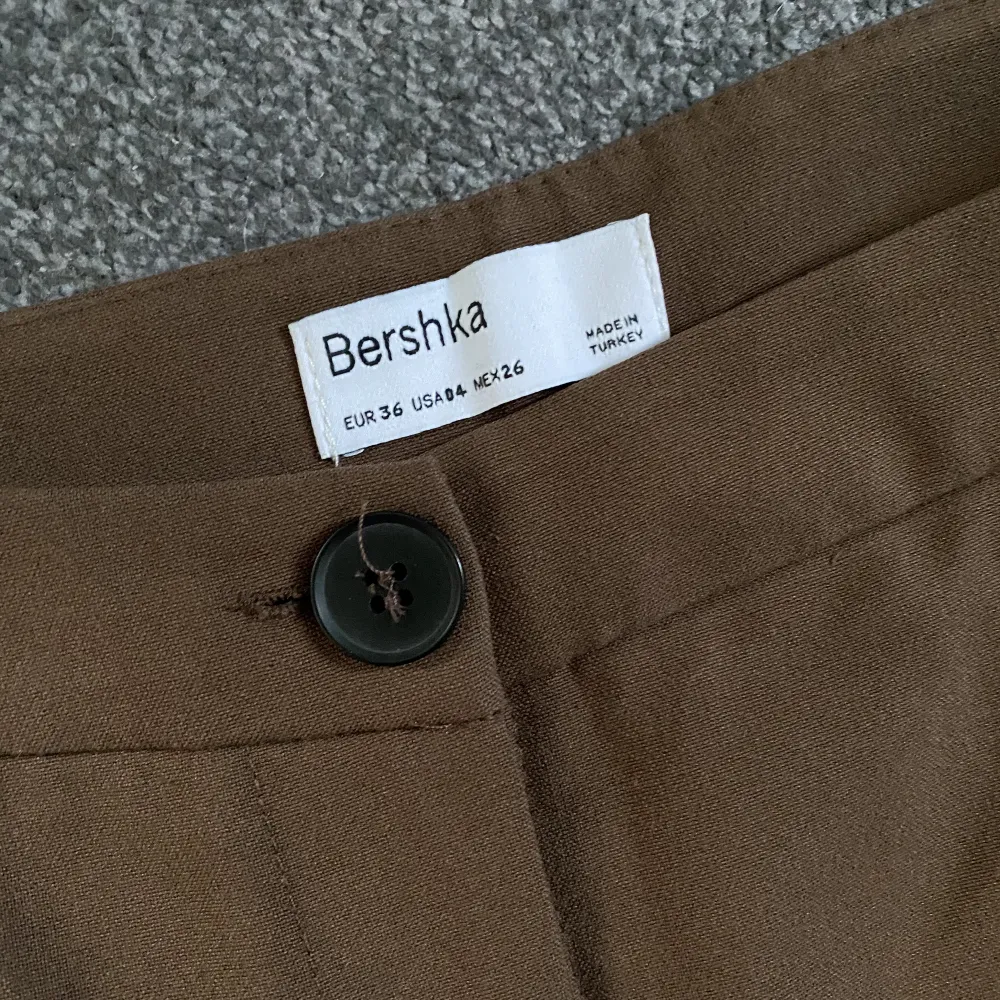 Bruna kostymbyxor från Bershka. Använd fåtal gånger. Stl 36. Nypris 300kr. . Jeans & Byxor.