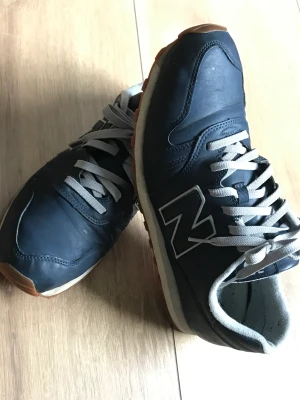 new balance herr 46,5  - New Balance herrmodell storlek 46,5 de passar storlekar fr 45 och 46,5  Skorna är använda men i väldigt bra skick. Inga defekter.  Materialet är läder och lätt att putsa de med en fuktig trasa.  Storlek  12 US  11,5 UK 46,5 EU 30 cm 