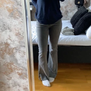 Bootcut jeans - Gråa bootcut jeans med en snitt där nere vid foten