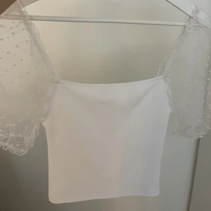 Vit topp med puffiga ärmar - Fin, vit topp med puffiga ärmar🤍 funkar även att ha ärmarna off-shoulder. Knappt använd. 