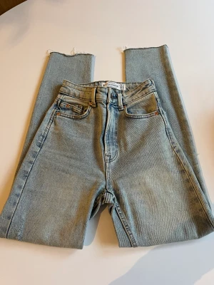 Jeans med hål - Jag säljer mina oanvända jeans från Stradivarius i storlek 32. De är high waist med hål vid båda knäna. Även elastiska. 