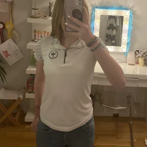 Vit rid T-shirt  - Vit rid T-shirt i fint skick. Skönt material när det är varm. Kronor på ärmarna. 