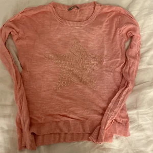 Rosa tröja i tunt tyg - Rosa tröja i tunt tyg med stjärna på magen. Knappt använd. Lagat hål bak på axeln som är lagat 