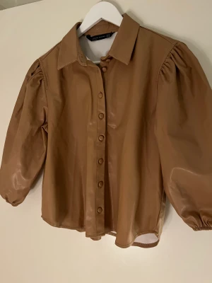 Blus i skinnimitation  - Brun/beige blus, skjorta i skinnimitation. 
