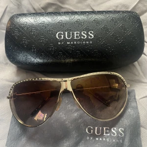 GUESS Solglasögon  - Säljer ett par GUESS solglasögon med fodral. I fint skick! 