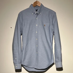 Ralph Lauren Skjorta - Tjena! Säljer en ljusblå Ralph lauren skjorta i storlek S, mycket sparsamt använd utan tecken på användning! Ny kostar skjortan cirka 1500 kr, mitt pris 499 kr! Hör gärna av dig vid frågor!