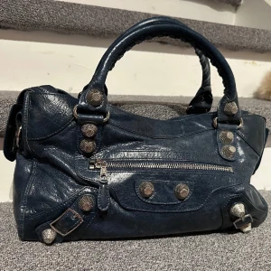 Balenciaga vintage city bag  - Balenciaga city bag, vintage. Fått i gåva. Slitage finns på kanter, se sista bild. Serienummer samt invändig logga finns. Kan skicka bild. Väldigt speciell och unik färg. Blå/grön. Silverdetaljer.   Ser om de finns intresse för denna otroligt fina väska. 