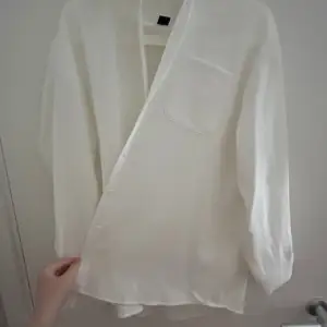 En vit skjorta som är använd en gång, jag hade den över en sommar klänning och den är inte obekväm alls. Jätte bra skick