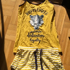 Harry Potter pyjamas set. Hufflepuff pyjamas set - En Hufflepuff pyjamas perfekt för dem som älskar Harry Potter. Tröjan är aldrig använd och shortsen är använda 2 ggr.