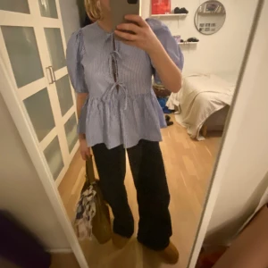 Blåvit blus - Säljer denna otroooliga blå och vit randiga blus med knyten framtill och ballongärmar! Den är i nyskick och i fin kvalitet. 