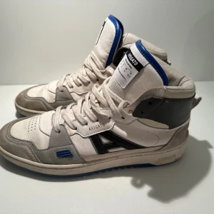 Axel Arigato stl 42 - Säljer höga Axel Arigato sneakers. Bra skick, har dock hål på insida hälar. Fungerar strålande både under vinter och vår.