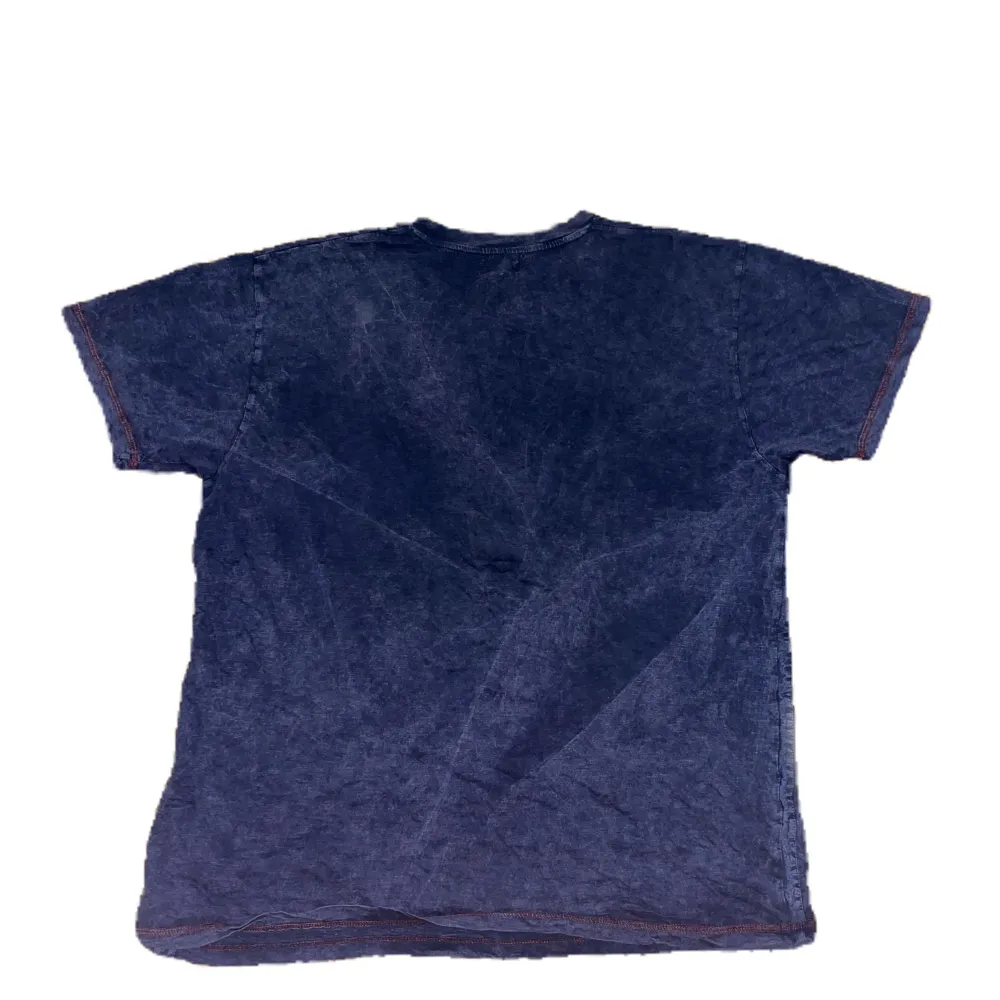 Tröjan vintage i en blå färg. Den har ett coolt tyck och med röda sömmar. Den är baggy (M-L). T-shirts.