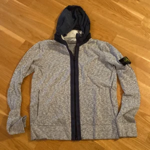 Stone Island jacka/kofta - Grå tunn Stone Islan jacka/kofta i bra skick, jackan har infällbar luva och är ej använd så mycket. Storleken är L men passar mig perfekt som är M