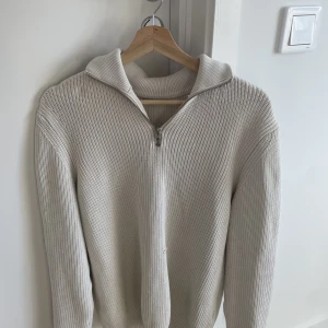 Zara vit halfzip  - Tja säljer denna half zip från zara. Stickad perfekt för höst o vinter. Skick:7/10 har en liten defekt då det finns ett litet hål vid magen men syns knappt på, skriv för fler bilder. Nypris:600