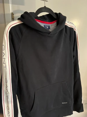 Gant Hoodie - Hej! Säljer en hoodie från Gant i storlek M. Den har Gant tryck längst med armarna och är i jättebra skick!  Jag köpte den på Boozt  Hör av dig vid frågor