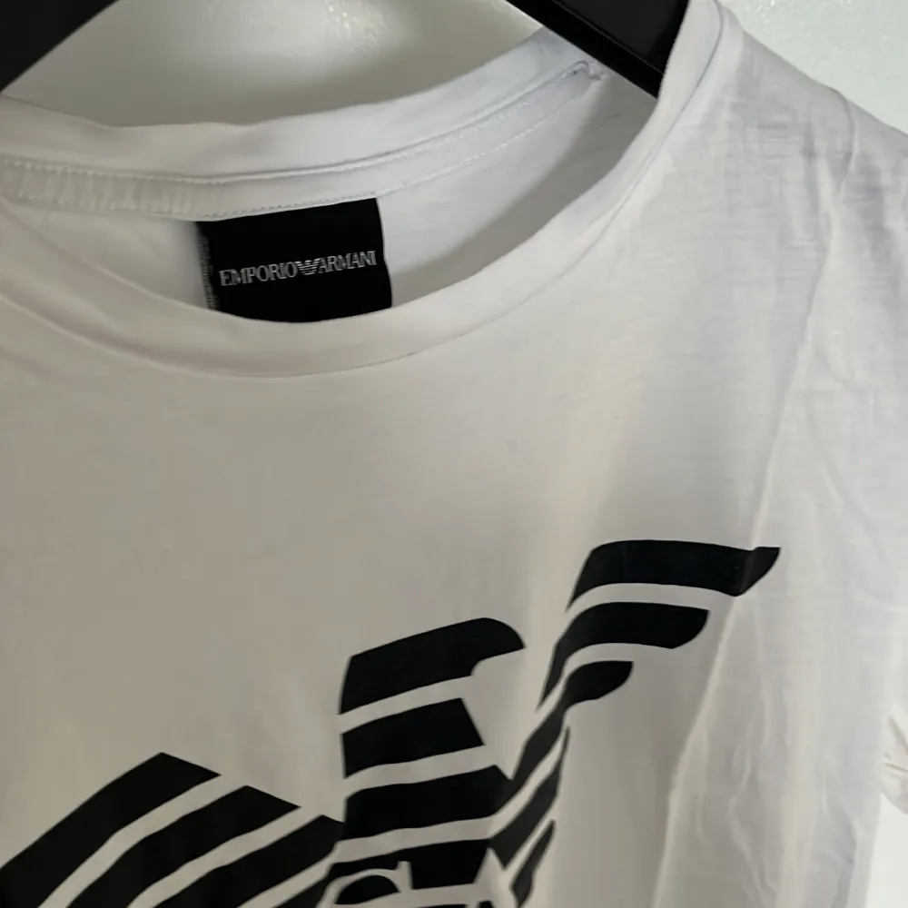 Vit Emporio Armani T-shirt i storlek M, funkar för strl S. Skicket är fint utan defekter. Som vanligt nås jag på dm för frågor mm.. T-shirts.