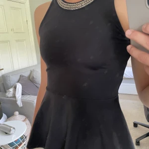 Peplum topp - Fin utsvängande topp från Nelly med fina detaljer i kragen. Säljer då den är lite liten på mig som är ca 180cm lång.