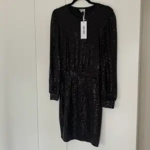Säljer denna svarta glittriga klänning då den ej kommit till användning. Nyskick!