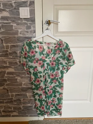 Blommig strandklänning  - Söt strandklänning i blommigt motiv. Använd ett fåtal gånger, perfekt skick. Storlek S men passar som M också.   Köpt för 399kr, säljer för 49kr. 