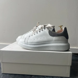 Alexander McQueen Sneakers - Alexander McQueen Sneakers använda men i bra skick!   Vita med grå detaljer bak.  Nya skosnören och orginalkartong ingår!  Nypris 5600, nu 4000! (Går att förhandla)