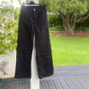 Svarta jeans med högmidja och vida ben, fickor fram och bak, aldrig använda 