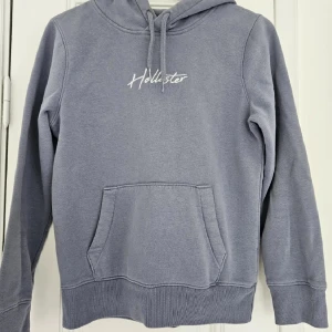 Hollister hoodie - Hoodie från hollister i gråblå färg. Har använts ett par gånger men är i fint skick! Passar perfekt inför hösten